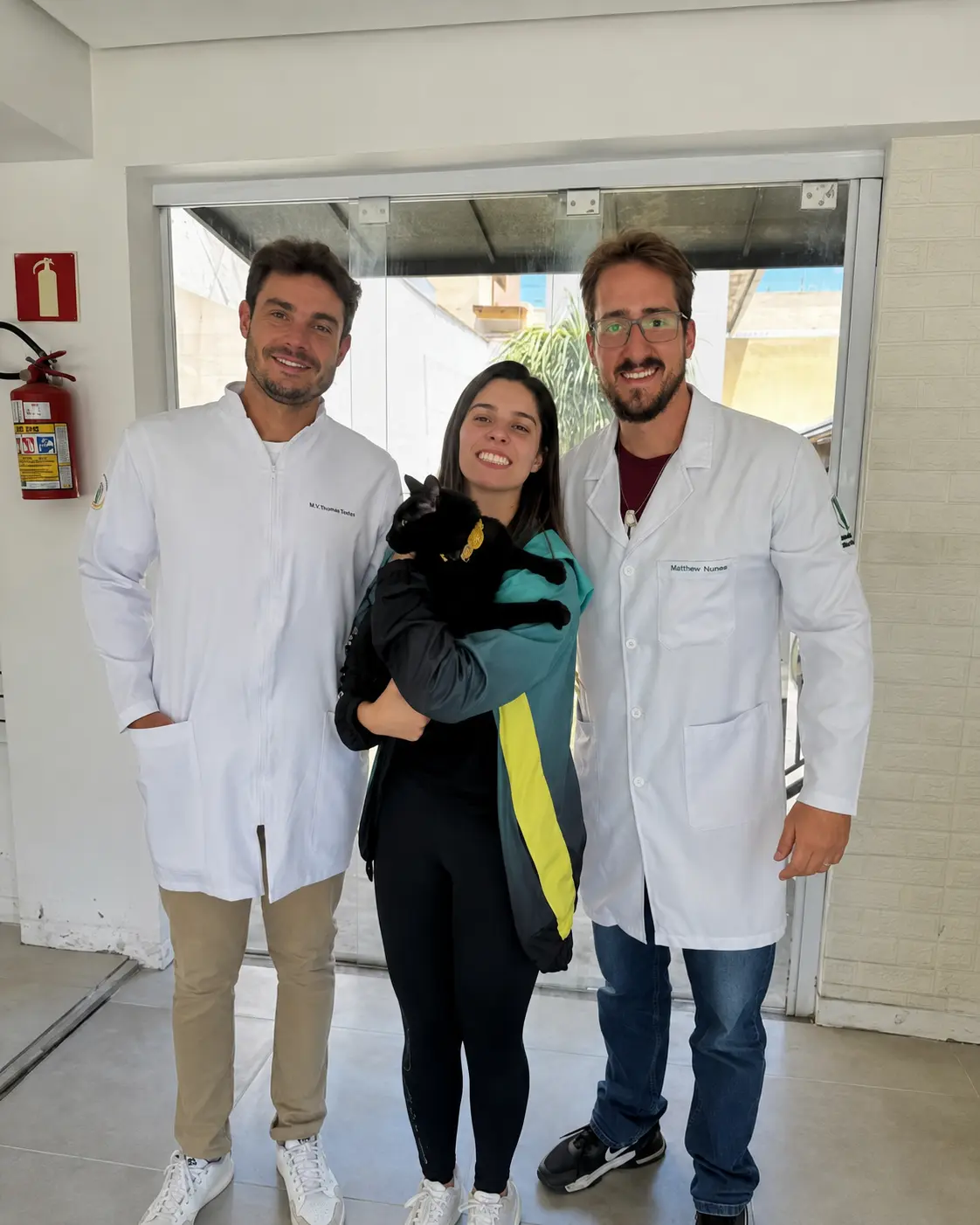Equipe Pataverso com cães na fachada do centro veterinário em Poços de Caldas